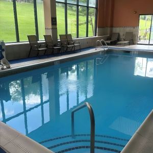 Indoor pool with seating area at Best Western Plus Hotel & Conference Center.