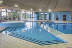 Indoor pool with seating area at DoubleTree By Hilton Glasgow Westerwood.