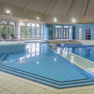 Indoor pool with seating area at DoubleTree By Hilton Glasgow Westerwood.