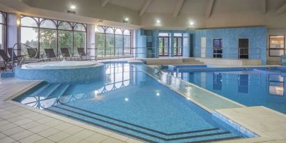 Indoor pool with seating area at DoubleTree By Hilton Glasgow Westerwood.