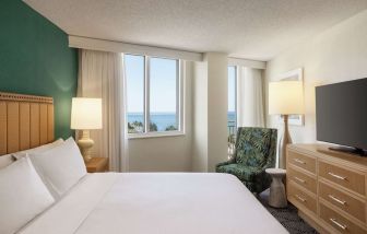 Romantic king room with TV at Embassy Suites By Hilton Deerfield Beach Resort & Spa.