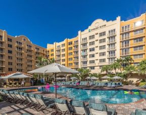 Stunning outdoor pool with loungers and umbrellas at Embassy Suites By Hilton Deerfield Beach Resort & Spa.