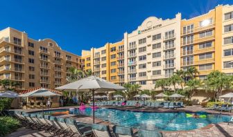 Stunning outdoor pool with loungers and umbrellas at Embassy Suites By Hilton Deerfield Beach Resort & Spa.