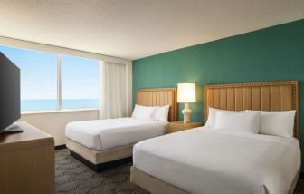 Two queen beds with TV and ocean view at Embassy Suites By Hilton Deerfield Beach Resort & Spa.