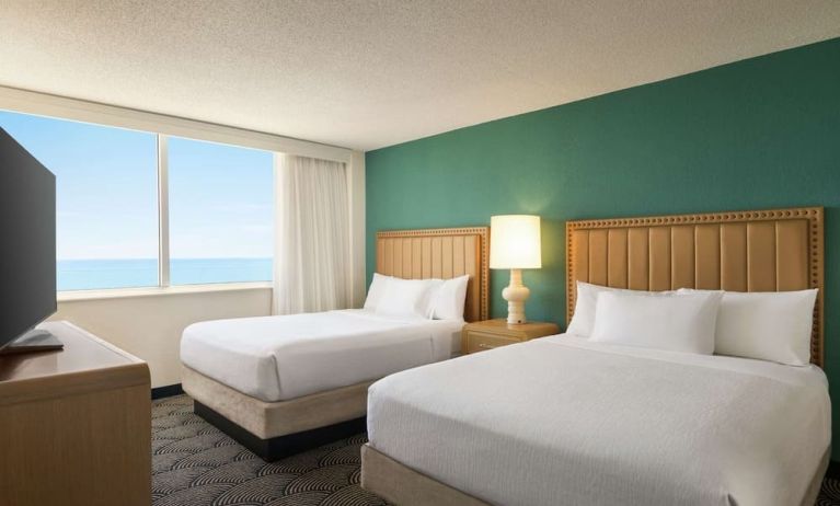 Two queen beds with TV and ocean view at Embassy Suites By Hilton Deerfield Beach Resort & Spa.