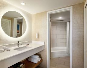 Guest bathroom with shower at Embassy Suites By Hilton Deerfield Beach Resort & Spa.