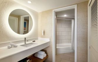 Guest bathroom with shower at Embassy Suites By Hilton Deerfield Beach Resort & Spa.