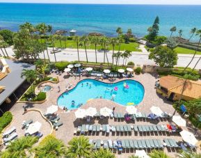 Outdoor pool with loungers at Embassy Suites By Hilton Deerfield Beach Resort & Spa.