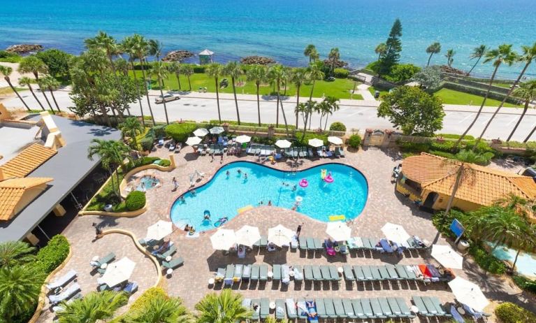 Outdoor pool with loungers at Embassy Suites By Hilton Deerfield Beach Resort & Spa.