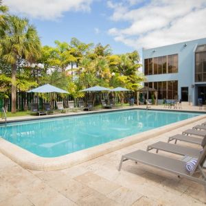 Outdoor pool with pool loungers at Regency Miami Airport By Sonesta.