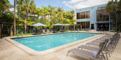 Outdoor pool with pool loungers at Regency Miami Airport By Sonesta.