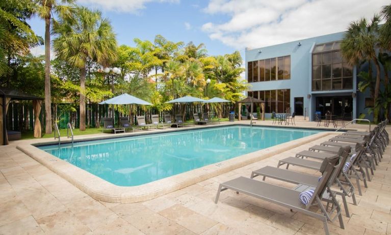 Outdoor pool with pool loungers at Regency Miami Airport By Sonesta.