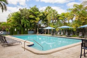 Outdoor pool with trees at Regency Miami Airport By Sonesta.