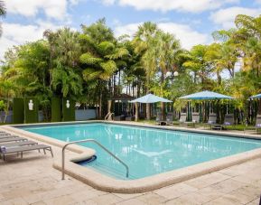 Outdoor pool with trees at Regency Miami Airport By Sonesta.