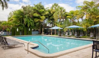 Outdoor pool with trees at Regency Miami Airport By Sonesta.