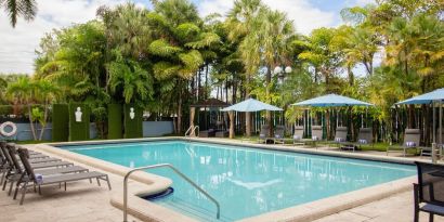 Outdoor pool with trees at Regency Miami Airport By Sonesta.