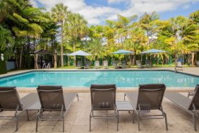 Outdoor pool with loungers at Regency Miami Airport By Sonesta.