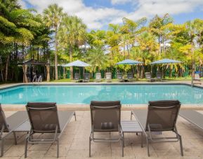 Outdoor pool with loungers at Regency Miami Airport By Sonesta.