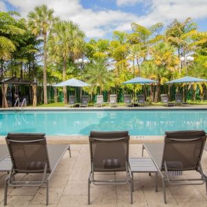 Outdoor pool with loungers at Regency Miami Airport By Sonesta.