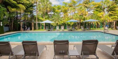 Outdoor pool with loungers at Regency Miami Airport By Sonesta.