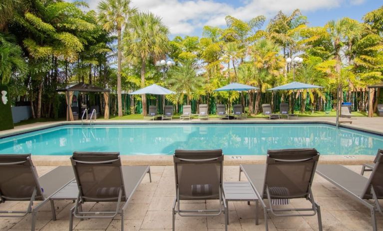 Outdoor pool with loungers at Regency Miami Airport By Sonesta.