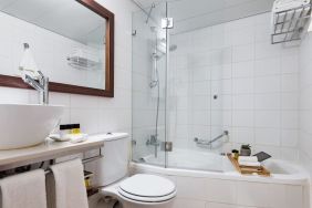 Guest bathroom with shower and bath at Prima Royale Hotel.