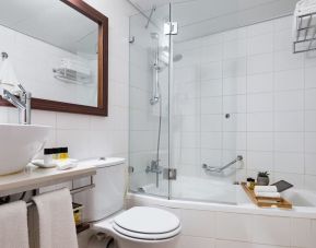 Guest bathroom with shower and bath at Prima Royale Hotel.