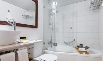 Guest bathroom with shower and bath at Prima Royale Hotel.