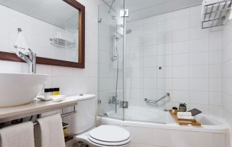 Guest bathroom with shower and bath at Prima Royale Hotel.