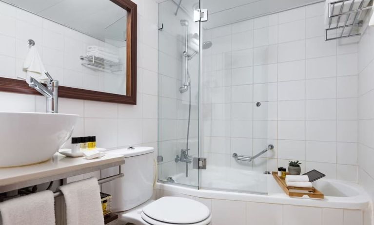 Guest bathroom with shower and bath at Prima Royale Hotel.