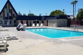 Outdoor pool with loungers at Economy Inn, Fresno.