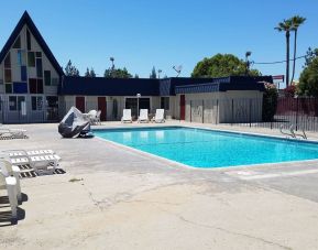 Outdoor pool with loungers at Economy Inn, Fresno.