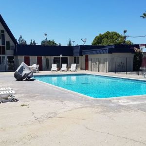 Outdoor pool with loungers at Economy Inn, Fresno.