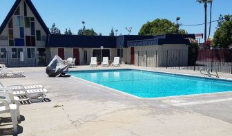 Outdoor pool with loungers at Economy Inn, Fresno.