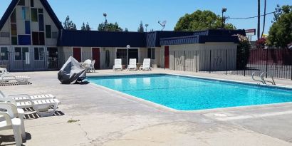 Outdoor pool with loungers at Economy Inn, Fresno.