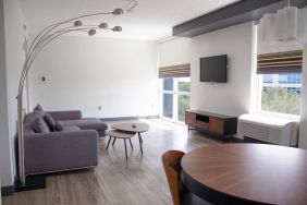 Hotel room with lounge and TV at Aloft Miami Doral.
