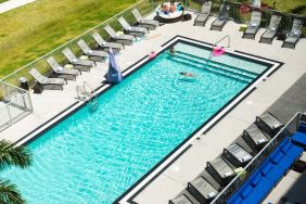 Outdoor pool with loungers at Aloft Miami Doral.
