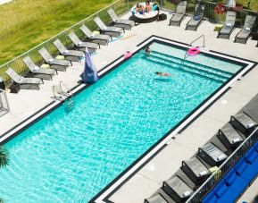 Outdoor pool with loungers at Aloft Miami Doral.
