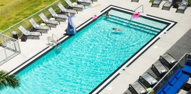 Outdoor pool with loungers at Aloft Miami Doral.
