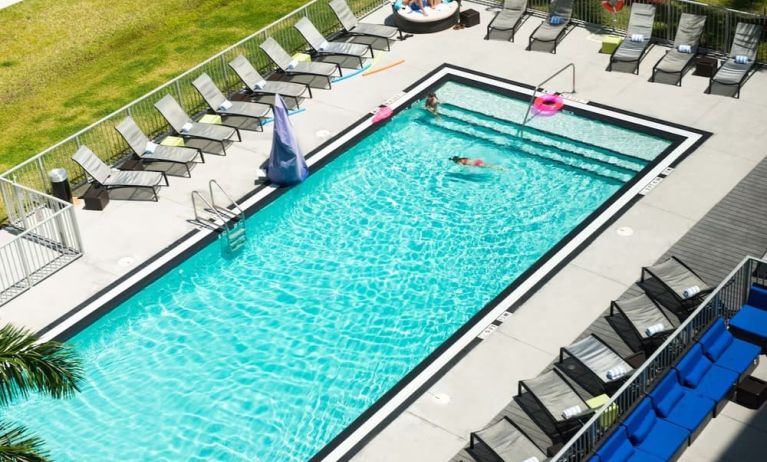 Outdoor pool with loungers at Aloft Miami Doral.
