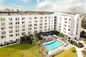 Hotel pool and hotel exterior at Aloft Miami Doral.
