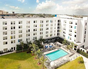 Hotel pool and hotel exterior at Aloft Miami Doral.
