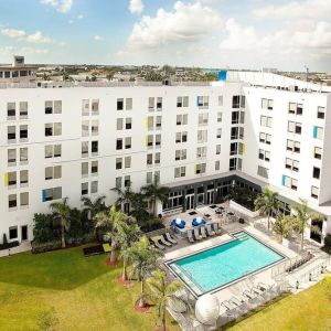 Hotel pool and hotel exterior at Aloft Miami Doral.
