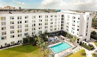 Hotel pool and hotel exterior at Aloft Miami Doral.
