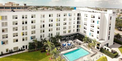 Hotel pool and hotel exterior at Aloft Miami Doral.
