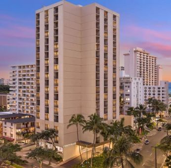 Hotel exterior at sunset at Hyatt Place Waikiki Beach.