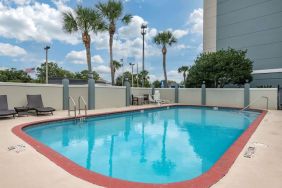 Outdoor pool with loungers at Comfort Suites Baymeadows Near Butler Blvd.