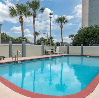 Outdoor pool with loungers at Comfort Suites Baymeadows Near Butler Blvd.