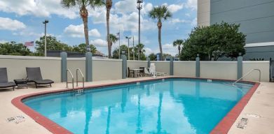 Outdoor pool with loungers at Comfort Suites Baymeadows Near Butler Blvd.