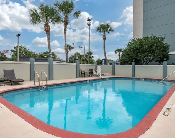 Outdoor pool with loungers at Comfort Suites Baymeadows Near Butler Blvd.